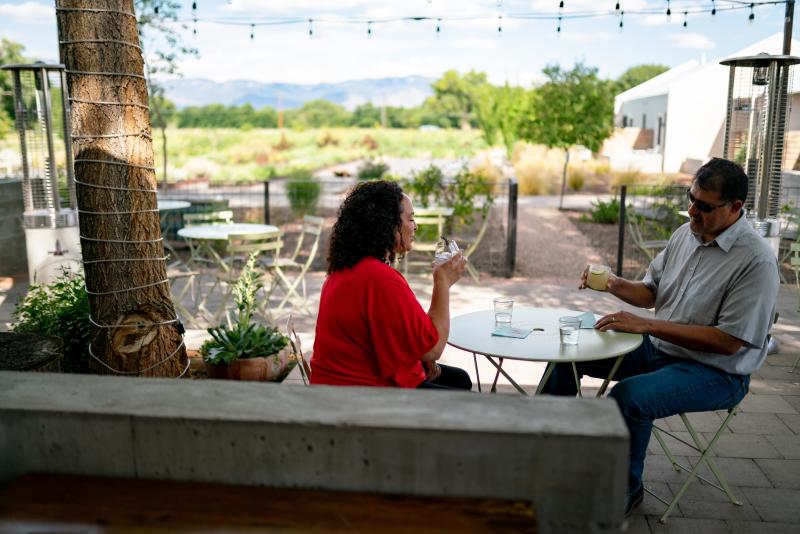 A couple sips drinks at Campo at Los Poblanos