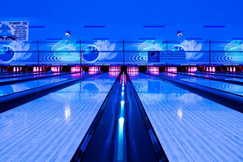 Bowling lanes lit by neon blue lights at Classic Lanes