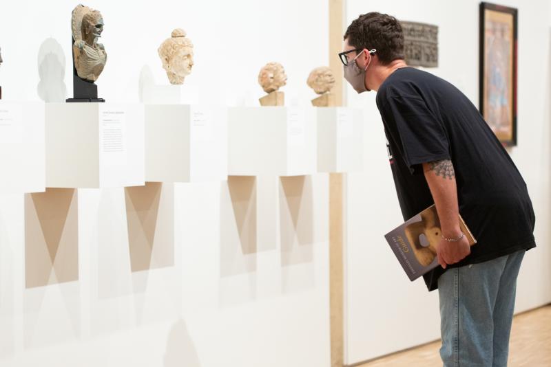 A visitor studies the collections of ancient busts at Eskenazi Museum of Art