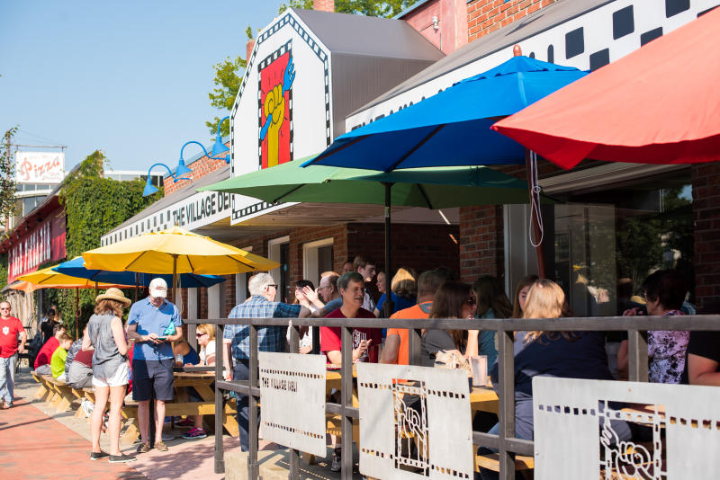 People dining on The Village Deli's patio