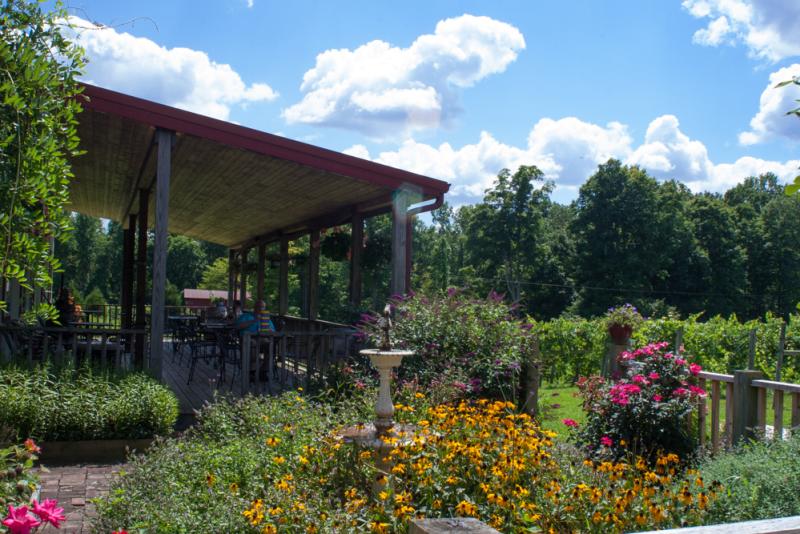 Butler Winery's outdoor patio, surrounded by wildflowers and lush greenery