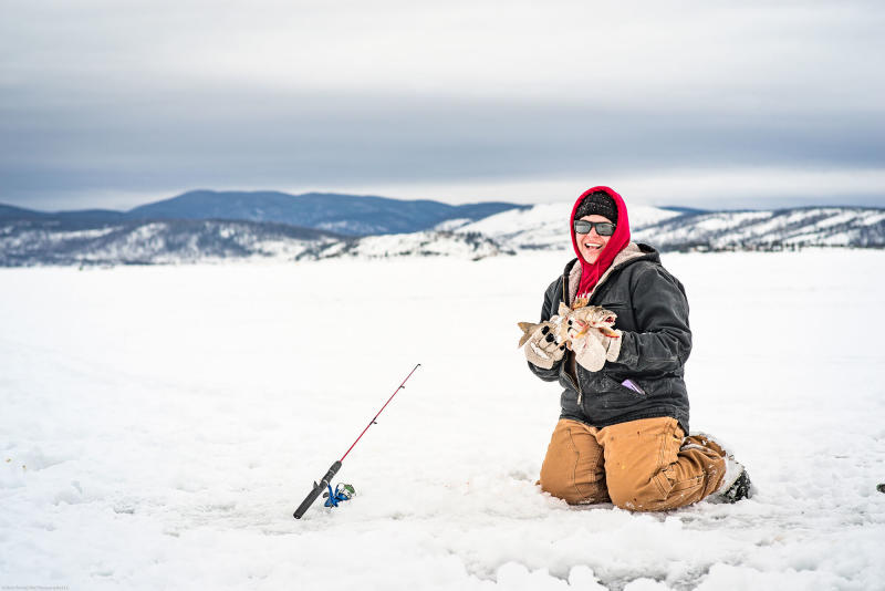 Woman holding fish at the 3 Lakes Ice Fishing Contest