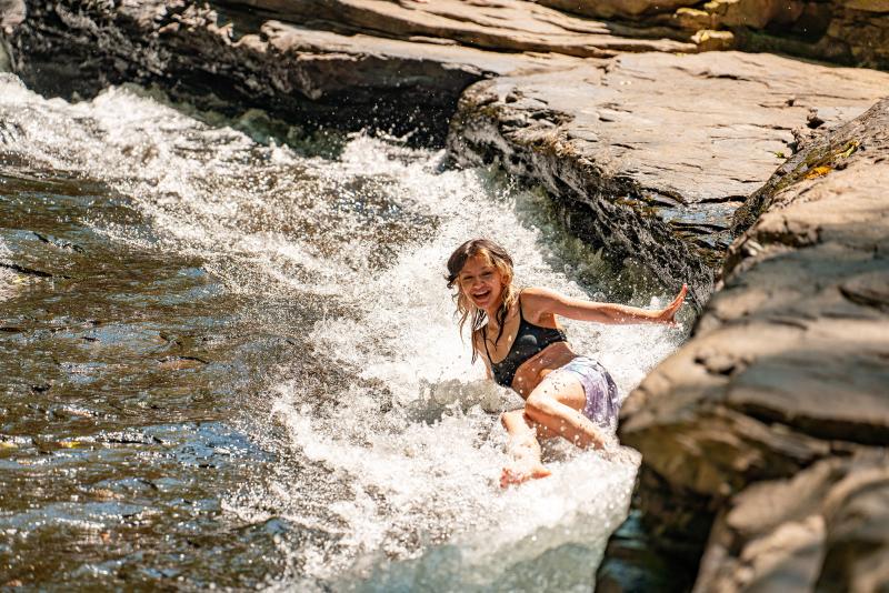 Girl sliding down natural waterslide at Ohiopyle