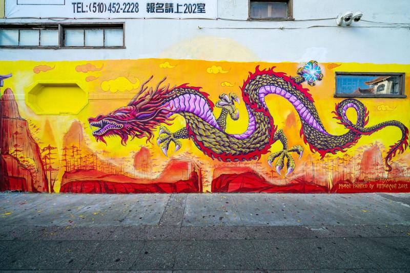 A vibrant mural of a dancing dragon at 340 10th Street in Oakland, California.