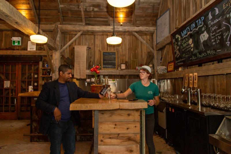 man at bar in brewery with server