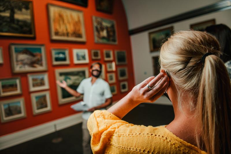 Woman using audio assistance in museum