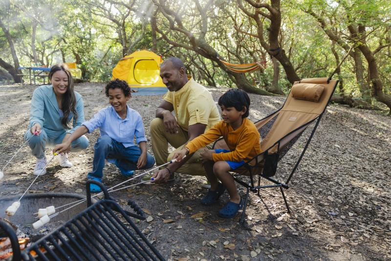 Family roasting marshmallows at campsite in First Landing State Park in Virginia Beach