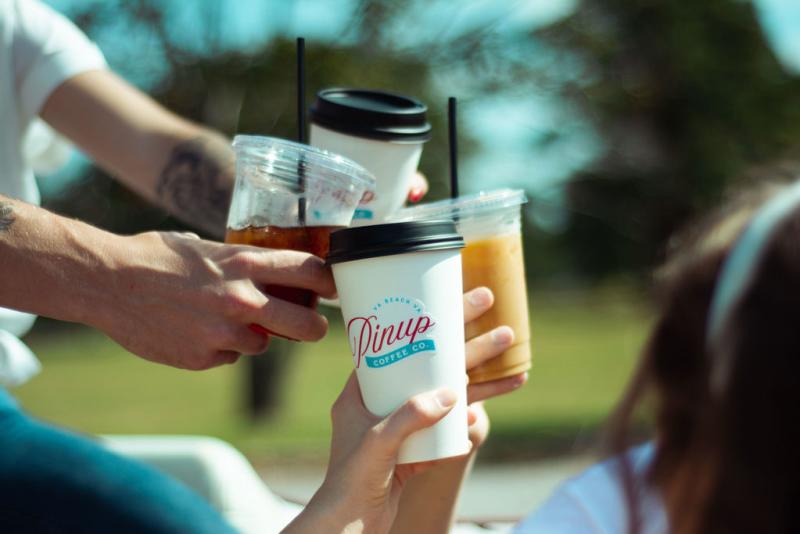 People cheering coffee drinks outside
