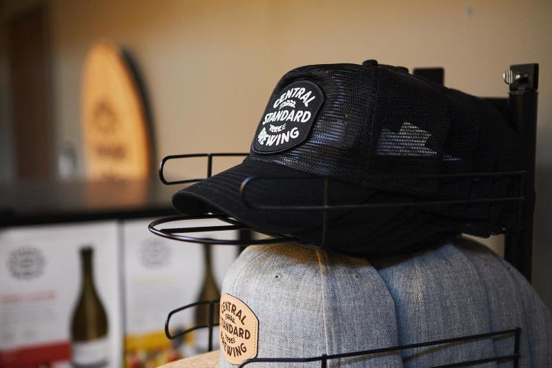 Two racks of hats, one black mesh the other heather gray, with the Central Standard Brewing logo