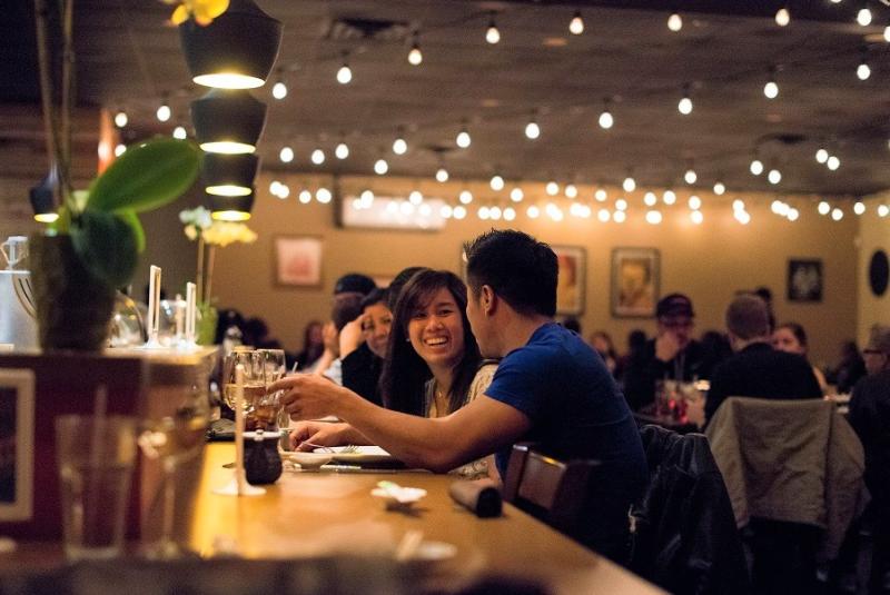 A couple sits at the bar enjoying a meal and drinks at Lemon Grass Thai