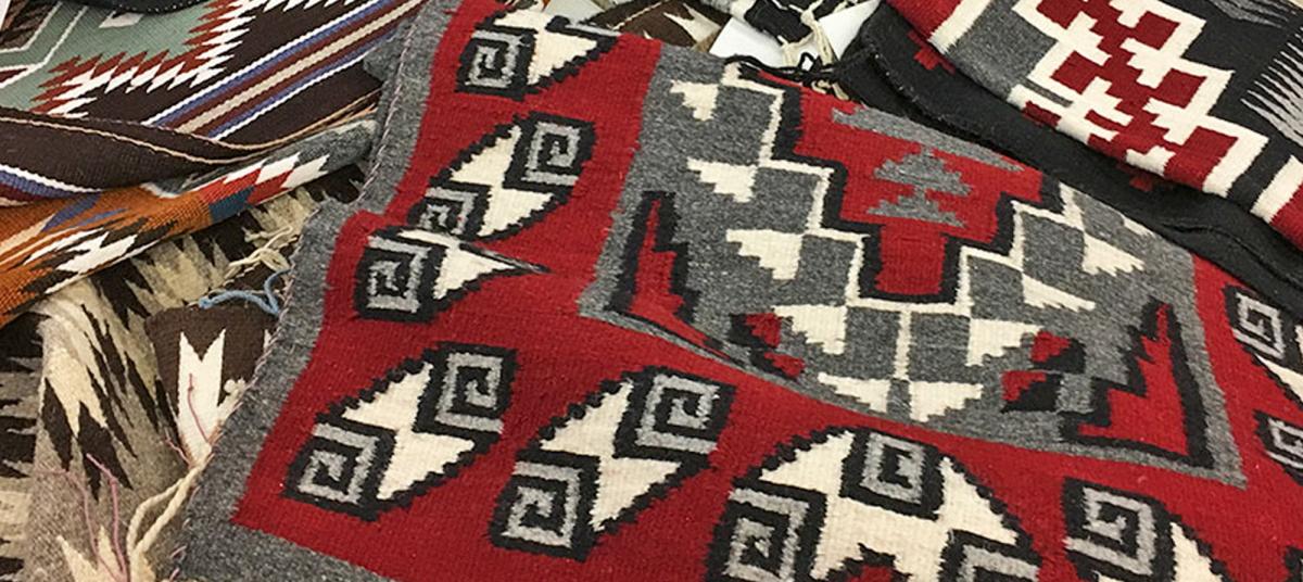 Navajo Rugs in a pile at the Crownpoint rug auction.
