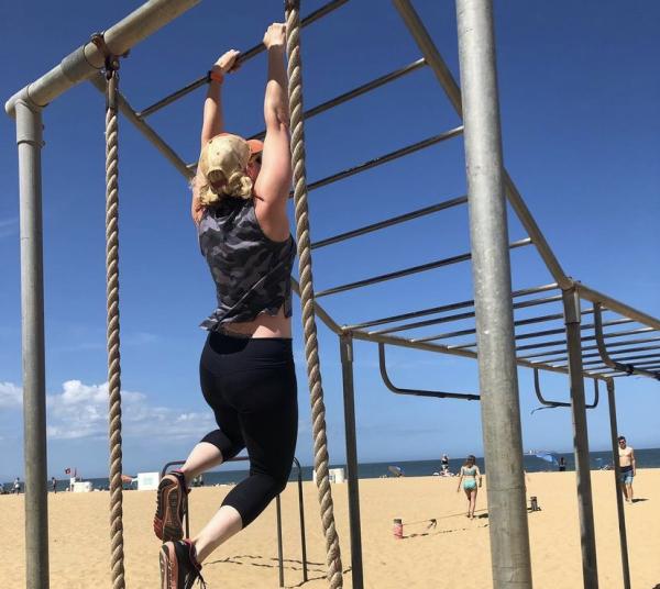 A woman holding onto a pull up bar.