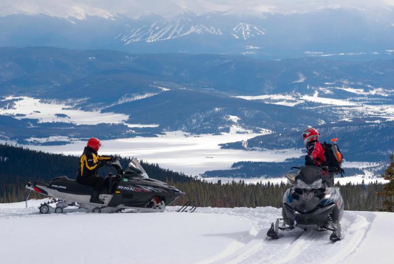 Snowmobiles overlooking Lake Granby and Granby Ranch