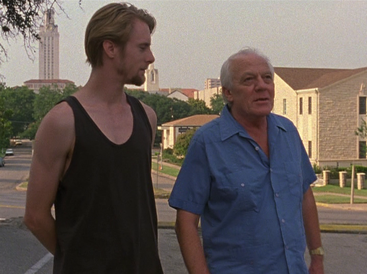 Slacker screengrab, two men are walking and talking on the road in front of the UT Tower