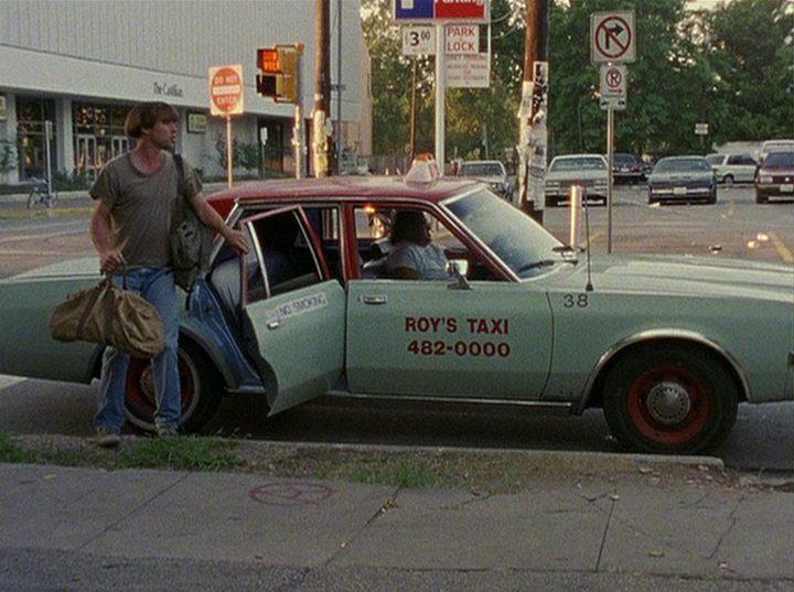 Slacker screengrab showing Richard Linklater getting out of a blue taxi that reads Roy's Taxis