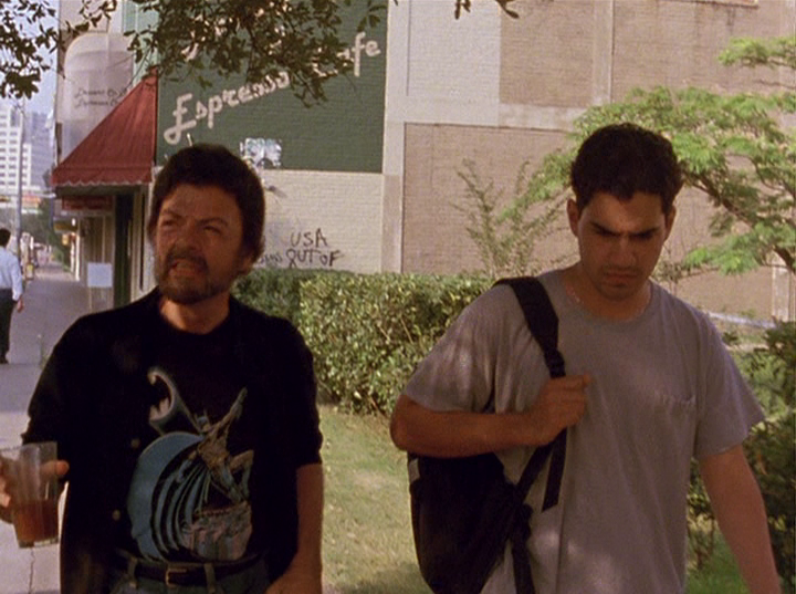 Slacker screengrab, showing two men walking together. Behind them, a sign on the side of a building reads Espresso Cafe