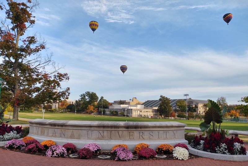 Three hot air balloons floating over IU