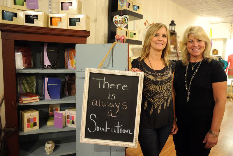 Full Heart Solutions owners standing next to sign
