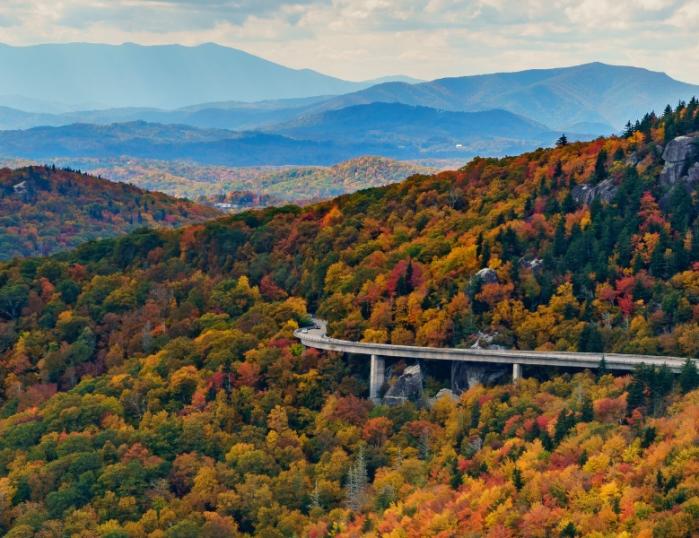 The Linn Cove Viaduct bridge in autumn with Blue Ridge Mountains all around.