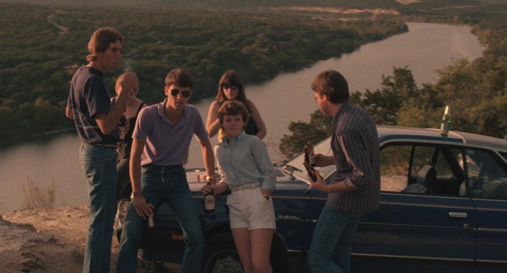 Blood Simple screengrab showing a group of young people leaning up against a car on top of Mount Bonnell