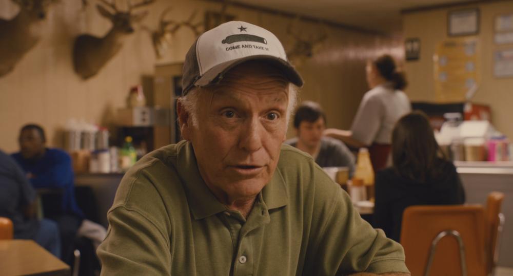 Bernie screengrab showing an older man wearing a "come and take it" baseball cap insider Zimmerhanzel's BBQ