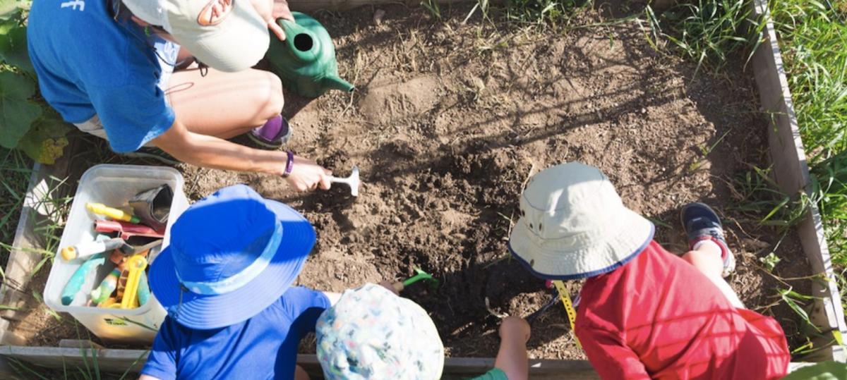 Kids digging in the dirt at Growing Gardens in Boulder