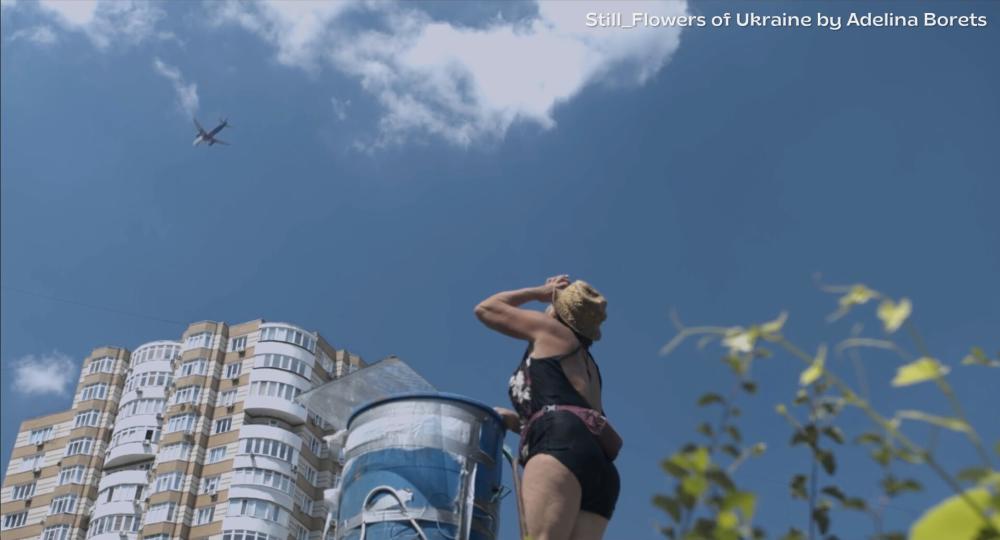 Woman looks up to sky as plane flies over