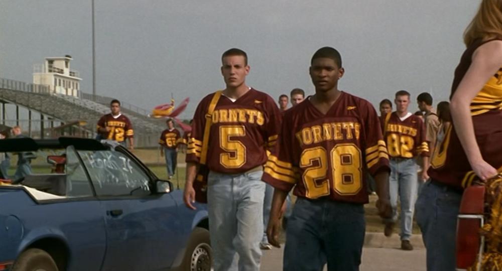 The Faculty screengrab, showing Usher and football players walking away from the Herrington High School Football Field