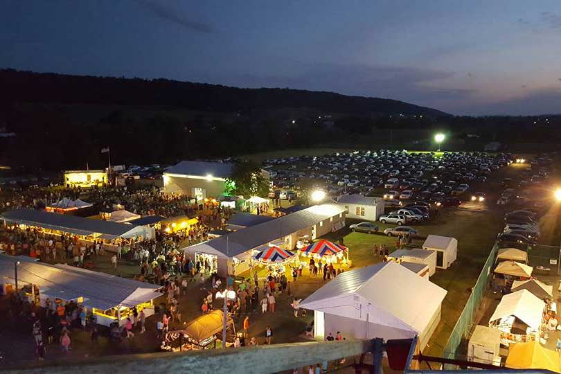 A large group of tents and a city at night