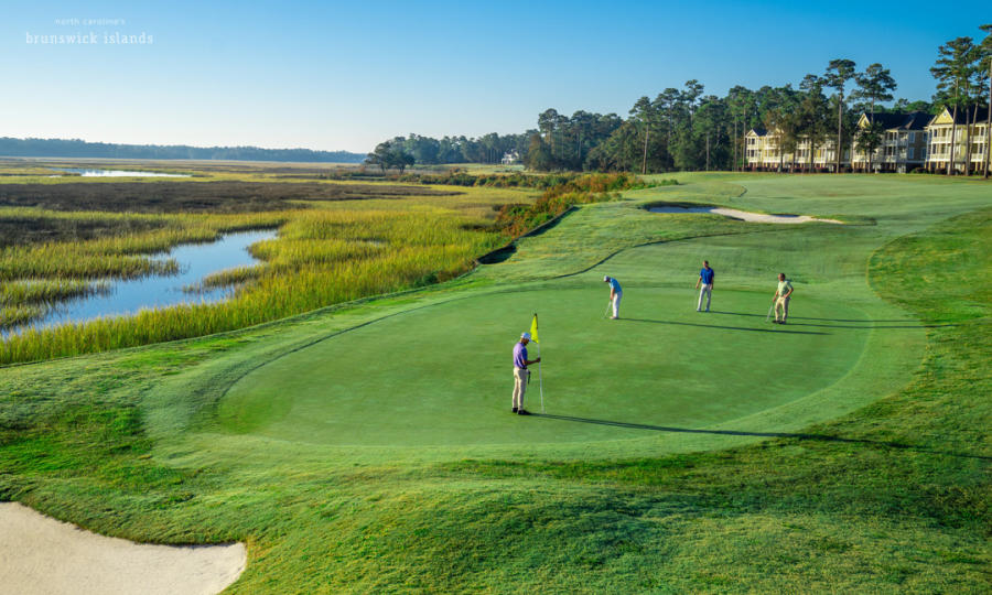 Golfing in North Carolina's Brunswick Islands, four men standing on a golf course green