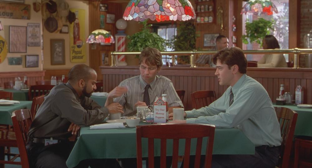 Office Space screengrab showing three men sitting around a table inside Chotchkies restaurant