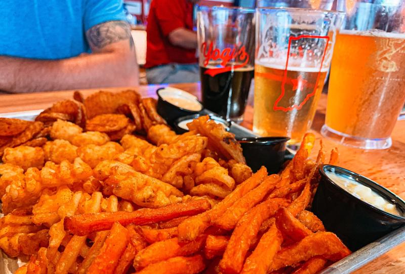 A fry flight and beers on a table at Yogi's