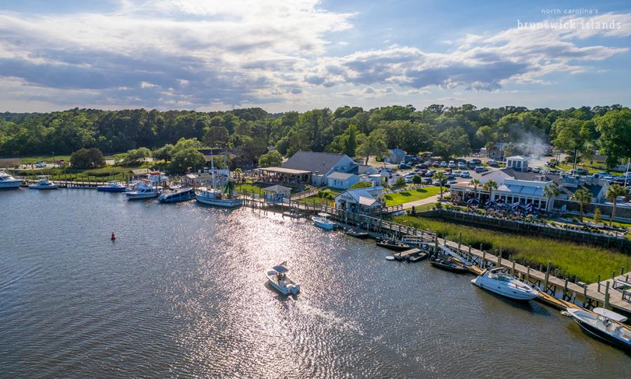 aerial view of a fishing village along a river with boats in the water