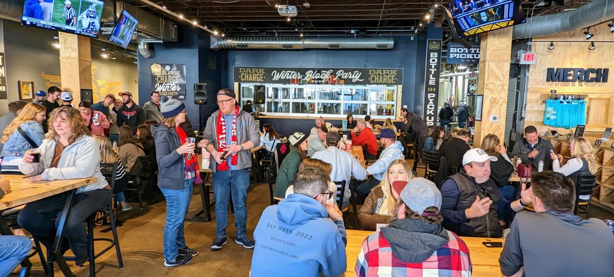 A crowd sitting and standing inside Braxton Brewing in Covington for the Dark Charge Winter Block Party