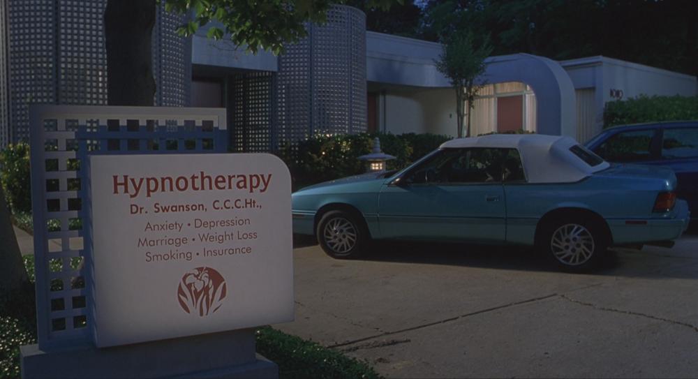 Office Space screengrab showing a blue convertible parked behind an office sign reading Hypnotherapy  Dr. Swanson, C.C.C.Ht., Anxiety, Depression, Marriage, Weight Loss, Smoking, Insurance