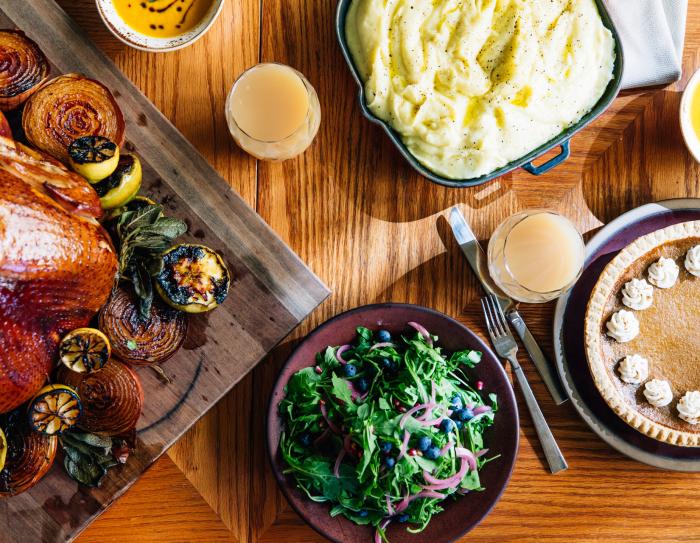 A Thanksgiving meal set on a table including turkey salad, pumpkin pie, and mashed potatoes.