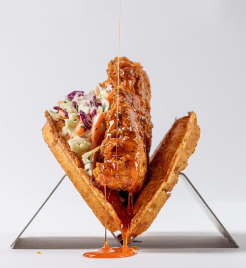 A waffle sandwich with chicken and coleslaw