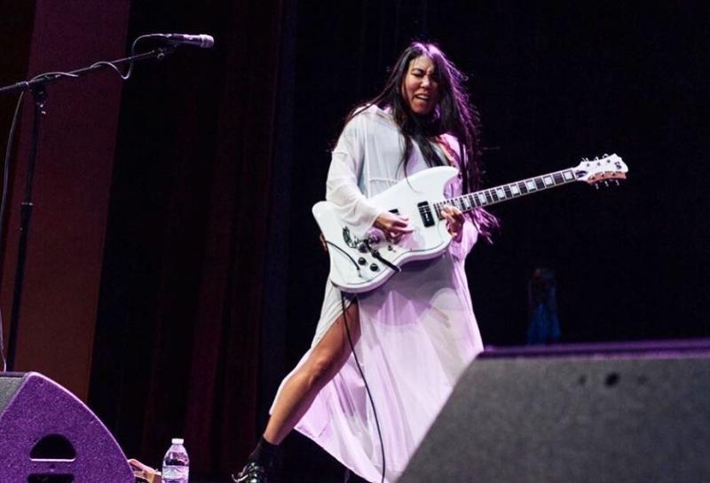 A woman playing electric guitar at the Buskirk-Chumley Theater