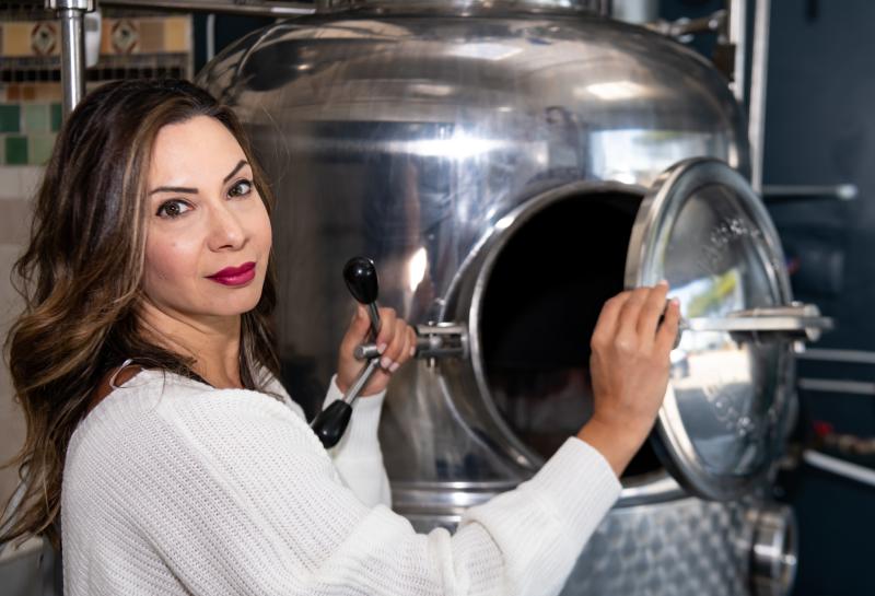 Owner Jamie Baddour in front of distillery equipment