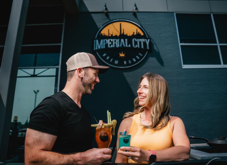 A couple on the patio holding a drink.