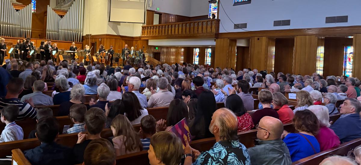 The New Mexico Philharmonic players take a bow as the audience applauds.
