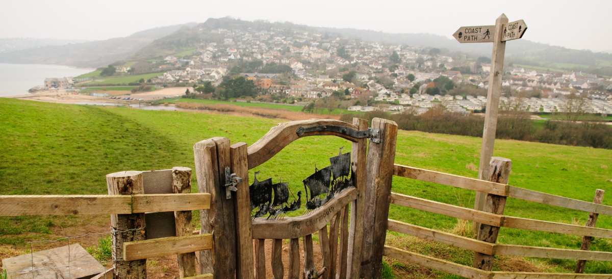 Picture showing sculpture on a gate overlooking Golden Cap on a misty day