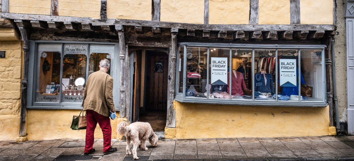 a man and his dog entering a quaint shop in Sherborne