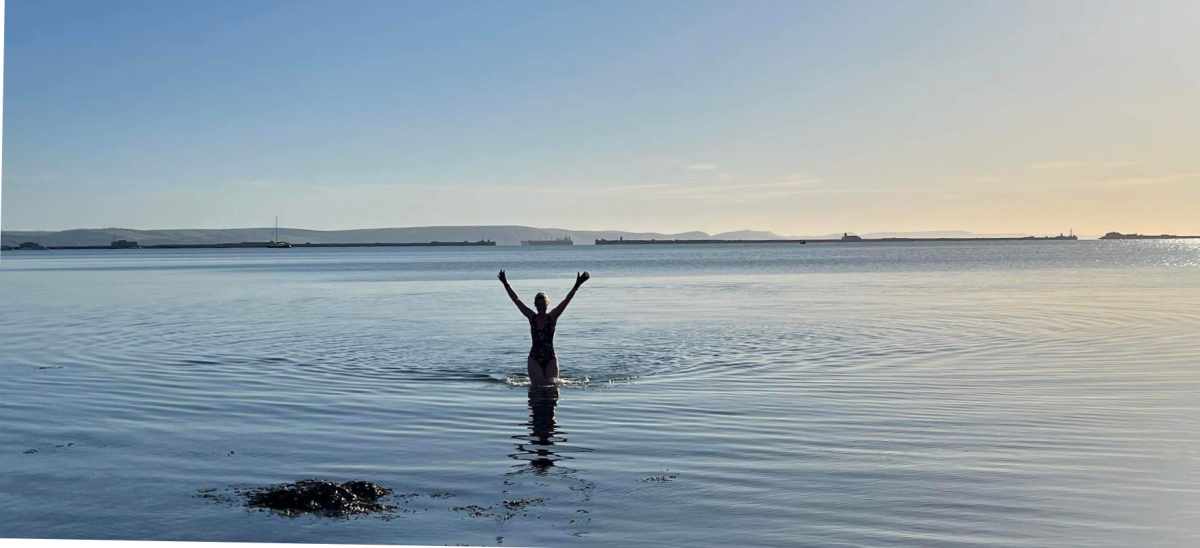 Swimmer with arms up at dawn