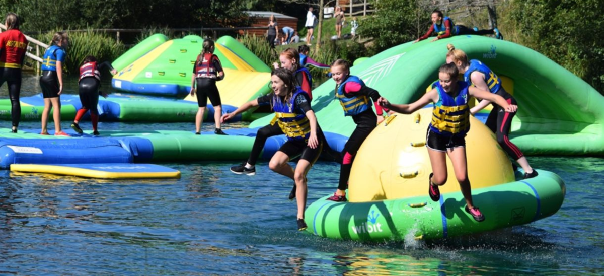 Young people jumping off inflatables at Dorset Adventure Park