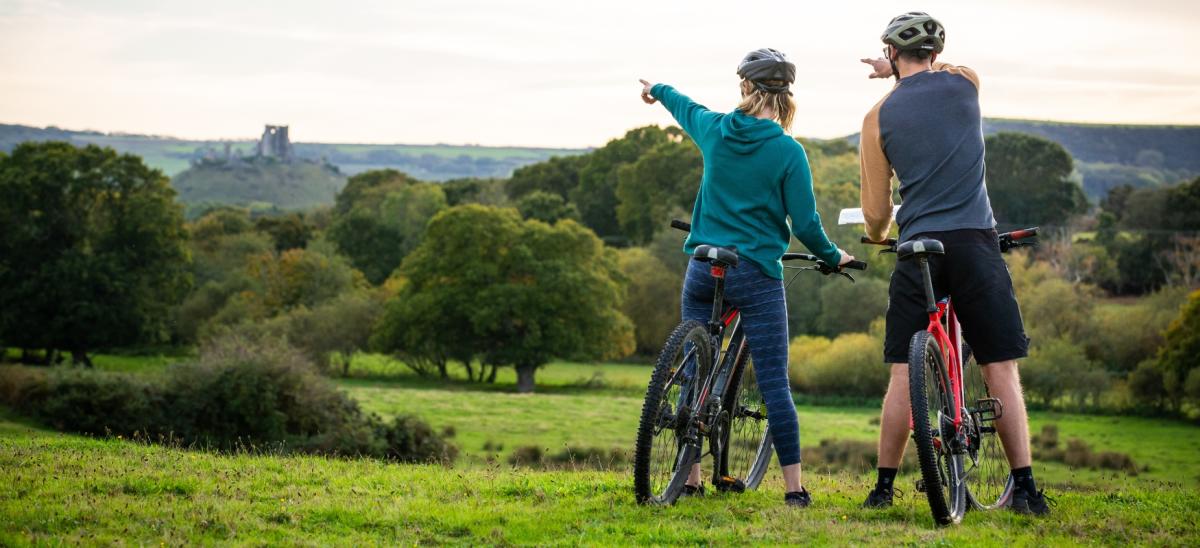 A woman and man cycling near Corfe Castle in Dorset