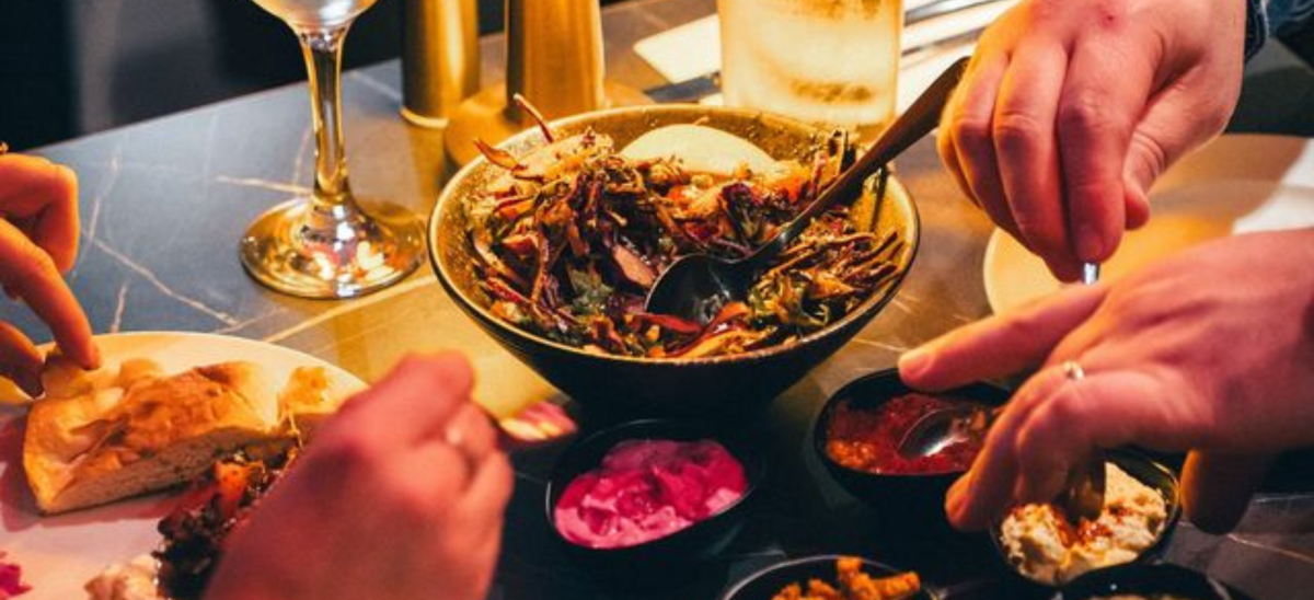 Close up of turkish cuisine at Meram Kitchen in Dorchester with hands eating.