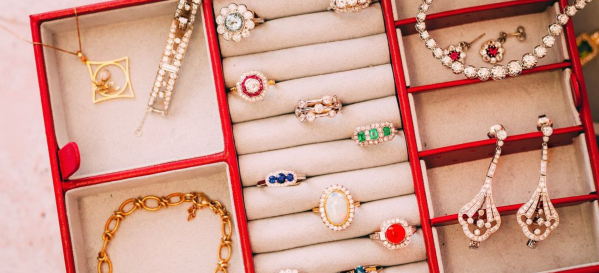 Pretty, colourful rings and necklaces on display in a box with red trim