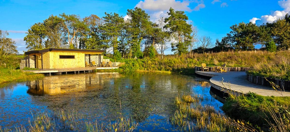 Pond and seating area at Holme For Gardens in Dorset
