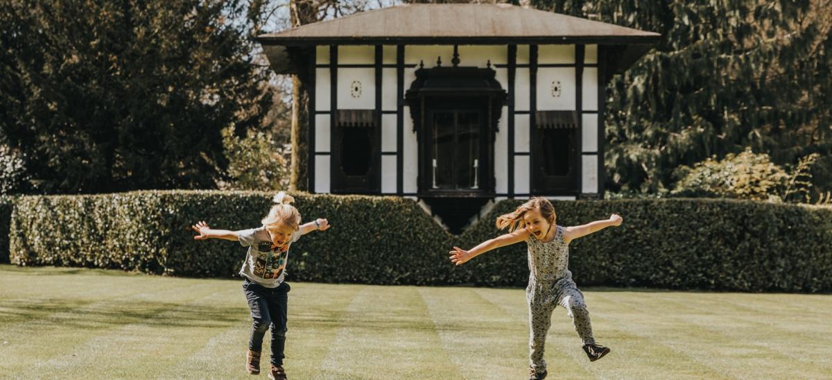 Two girls running on the lawns at Larmer Tree Gardens in Dorset